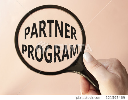 Partner Program symbol. Concept words Partner Program on magnifying glass. Businessman hand. Beautiful pink background. Business and Partner Program concept. Copy space. 121595469