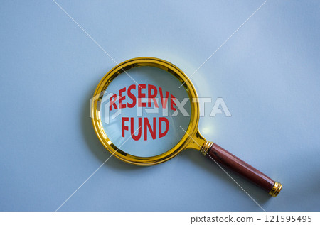 Reserve Fund symbol. Magnifying Glass with Concept word Reserve Fund. Beautiful blue background. Business and Reserve Fund concept. Copy space 121595495