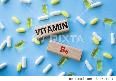 Vitamin B6 symbol. Concept word Vitamin B6 on wooden blocks. Beautiful blue background with pills. Medicine and Vitamin B6 concept. Copy space Vitamin B6 symbol. Concept word Vitamin B6 on wooden blocks. Beautiful blue background with pills. Medicine and Vitamin B6 concept. Copy space 121595784