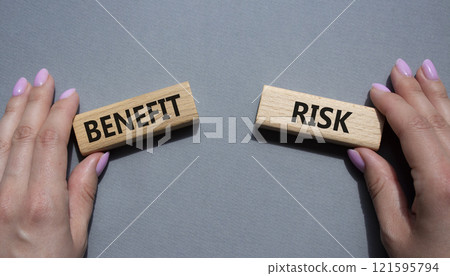 Risk or Benefit symbol. Concept word Risk or Benefit on wooden blocks. Businessman hand. Beautiful grey background. Business and Risk or Benefit concept. Copy space Risk or Benefit symbol. Concept word Risk or Benefit on wooden blocks. Businessman hand. Beautiful grey background. Business and Risk or Benefit concept. Copy space 121595794
