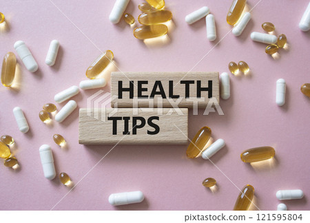 Health Tips symbol. Wooden blocks with words Health Tips. Beautiful pink background with pills. Medicine and Health Tips concept. Copy space. Health Tips symbol. Wooden blocks with words Health Tips. Beautiful pink background with pills. Medicine and Health Tips concept. Copy space. 121595804