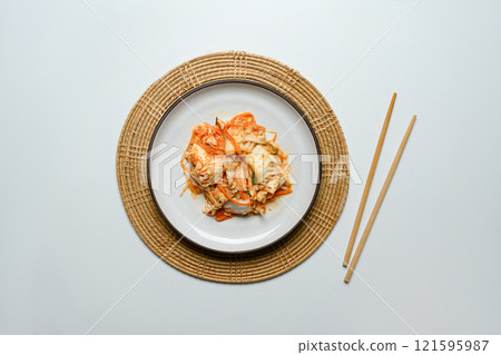 Traditional Korean Kimchi on a rustic Plate accompanied by wooden chopsticks. Korean cuisine and traditional side dish concept 121595987