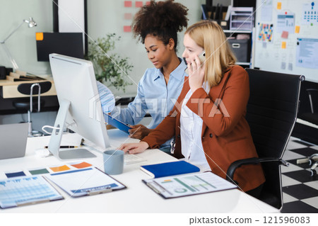 Diverse professionals collaborate on project analysis with financial graphs. Strategic teamwork and insights drive company growth and success. 121596083