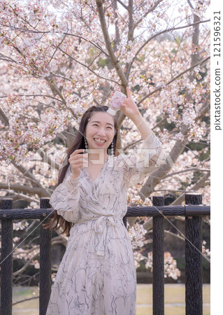 Young woman posing under the cherry tree Young woman posing under the cherry tree 121596321