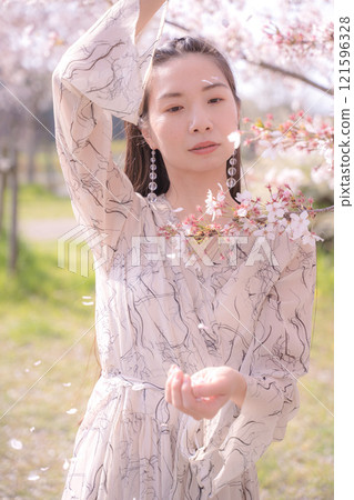 A woman spreading her arms under the cherry tree A woman spreading her arms under the cherry tree 121596328