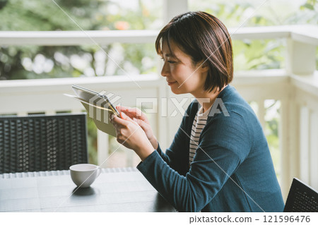 Woman using a tablet on the terrace 121596476