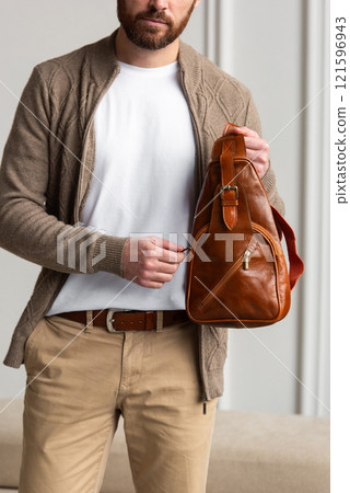 A Stylish and Professional Man Standing with a yellow brown hip pack in a Contemporary Modern Setting. A Stylish and Professional Man Standing with a yellow brown hip pack in a Contemporary Modern Setting. 121596943
