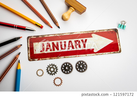 January. Red arrow with text on a white office desk 121597172