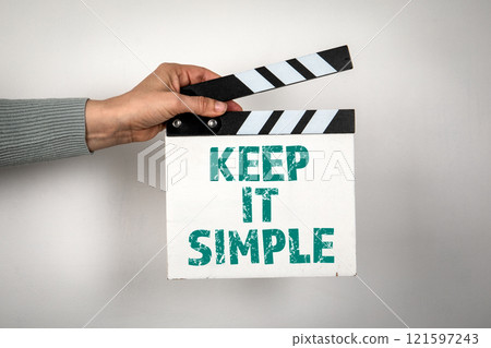 Keep it simple. Hand holding movie clapper 121597243