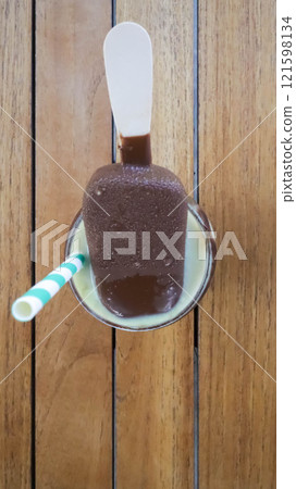 Avocado juice with chocolate lava and chocolate ice cream popsicle stick toppings. 121598134