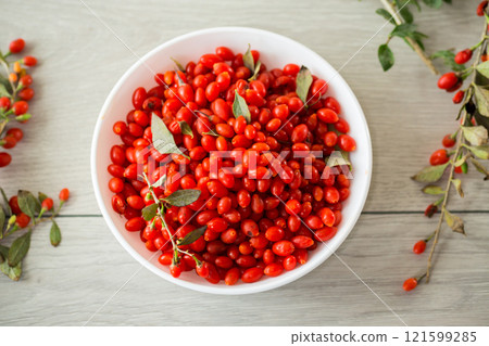 fresh ripe red goji berries in a bowl on a wooden table 121599285