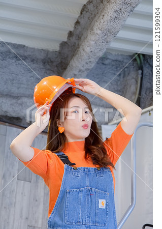Young woman painting a wall 121599304