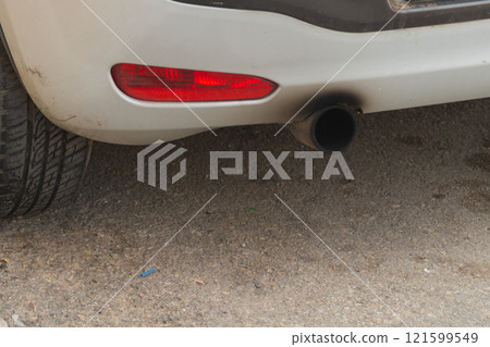 A malfunctioning engine and exhaust afterburner system show the results of their actions in the form of black soot over the muffler of an internal combustion vehicle. Incorrect operation consequences. 121599549