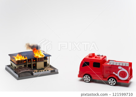 [Partly AI-generated] A fire engine rushing to a fire and a burning house 121599710