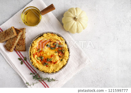 Homemade pumpkin chickpea hummus in a bowl on light background.Top view, copy space for recepie 121599777