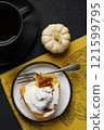 Pumpkin bun or cinnabon with spices on plate and cup of tea on black background. Thanksgiving Food Concept. Autumn concept top view 121599795
