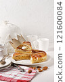 King cake or galette des rois in French. Traditional epiphany pie with golden paper crown and tiny charms 121600084