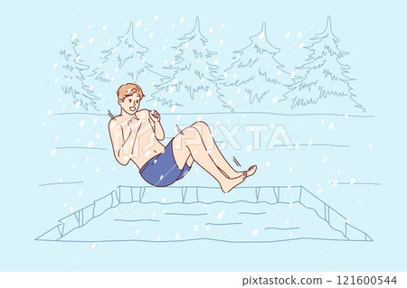 Man hardens himself by swimming in cold winter pond, jumping into icy water during snowfall 121600544