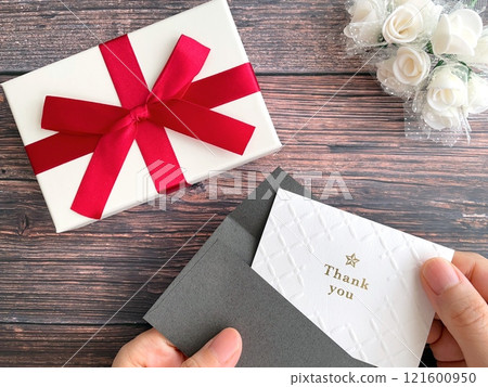 拿著禮物盒和留言卡的手 121600950