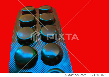 Blister with pills on back side on red background close-up with perspective Blister with pills on back side on red background close-up with perspective 121601026