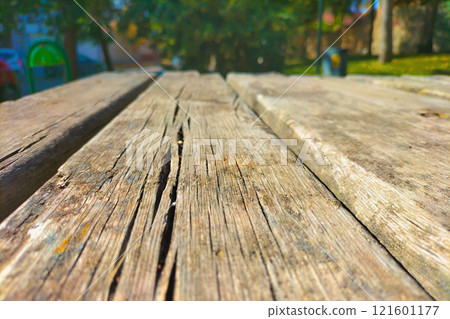 Texture of the old weathered street table desk on the public park. Example of the weathering and destruction of materials under the natural factors, like heat, sun, uv-lights, cold, humidity, wind Texture of the old weathered street table desk on the public park. Example of the weathering and destruction of materials under the natural factors, like heat, sun, uv-lights, cold, humidity, wind 121601177
