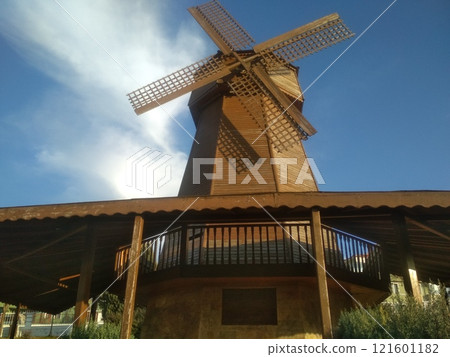 The wooden windmill has become a recognizable character in a novel by a Spanish writer on partly cloudy sky background 121601182