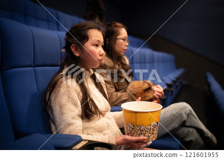Parents and children eating popcorn and watching a movie 121601955