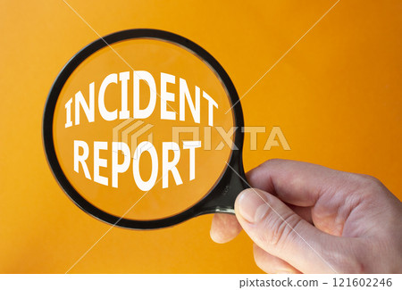 Incident Report symbol. Concept word Incident Report on magnifying glass. Businessman hand. Beautiful orange background. Business and Incident Report concept. Copy space 121602246