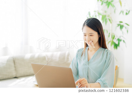 一位女士在客廳使用電腦 121602386