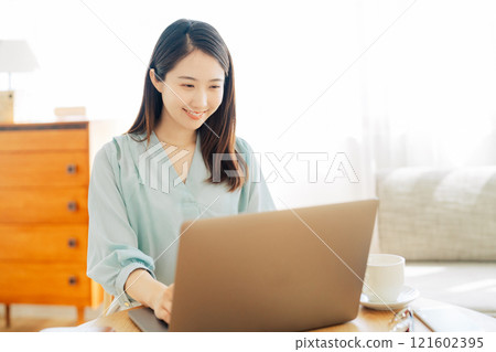 一位女士在客廳使用電腦 121602395