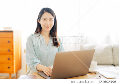 一位女士在客廳使用電腦 121602396