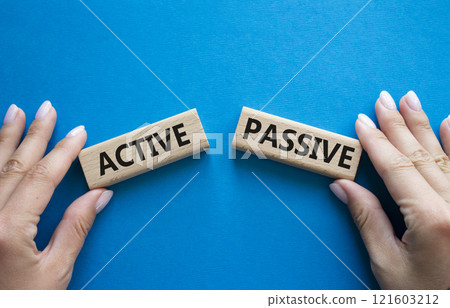 Active or Passive symbol. Concept word Active or Passive on wooden blocks. Businessman hand. Beautiful blue background. Business and Active or Passive concept. Copy space Active or Passive symbol. Concept word Active or Passive on wooden blocks. Businessman hand. Beautiful blue background. Business and Active or Passive concept. Copy space 121603212