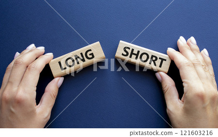 Short vs Long symbol. Concept word Short vs Long on wooden blocks. Businessman hand. Beautiful deep blue background. Business and Short vs Long concept. Copy space 121603216