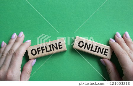 Offline or Online symbol. Concept word Offline or Online on wooden blocks. Businessman hand. Beautiful green background. Business and Offline or Online concept. Copy space Offline or Online symbol. Concept word Offline or Online on wooden blocks. Businessman hand. Beautiful green background. Business and Offline or Online concept. Copy space 121603218