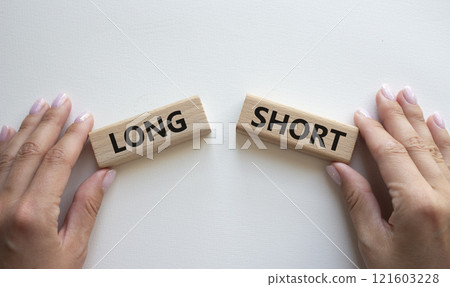 Short vs Long symbol. Concept word Short vs Long on wooden blocks. Businessman hand. Beautiful white background. Business and Short vs Long concept. Copy space Short vs Long symbol. Concept word Short vs Long on wooden blocks. Businessman hand. Beautiful white background. Business and Short vs Long concept. Copy space 121603228