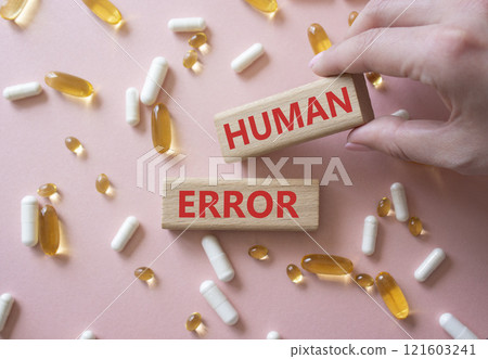 Human Error symbol. Concept word Human Error on wooden blocks. Beautiful pink background with pills. Doctor Hand. Medicine and Human Error concept. Copy space Human Error symbol. Concept word Human Error on wooden blocks. Beautiful pink background with pills. Doctor Hand. Medicine and Human Error concept. Copy space 121603241
