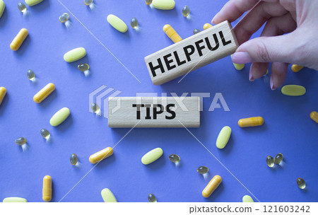 Helpful tips symbol. Concept word Helpful tips on wooden blocks. Doctor Hand. Beautiful purple background with pills. Medicine and Helpful tips concept. Copy space Helpful tips symbol. Concept word Helpful tips on wooden blocks. Doctor Hand. Beautiful purple background with pills. Medicine and Helpful tips concept. Copy space 121603242