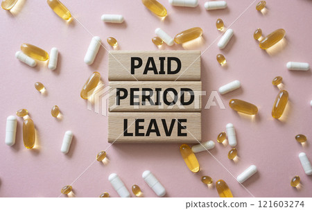 Paid Period Leave symbol. Concept words Paid Period Leave on wooden blocks. Beautiful pink background with pills. Healthcare and Paid Period Leave concept. Copy space. 121603274