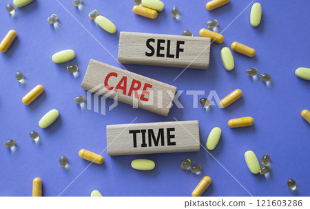 Self-care Time symbol. Concept words Self-care Time on wooden blocks. Beautiful purple background with pills. Healthcare and Self-care Time concept. Copy space. Self-care Time symbol. Concept words Self-care Time on wooden blocks. Beautiful purple background with pills. Healthcare and Self-care Time concept. Copy space. 121603286