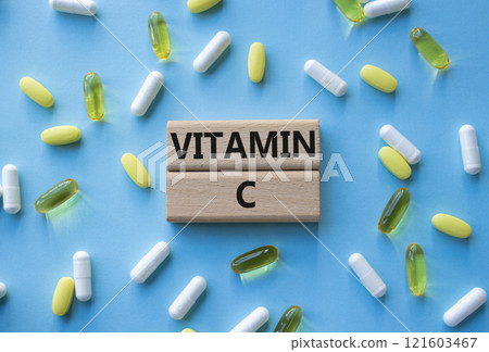 Vitamin C symbol. Concept word Vitamin C on wooden blocks. Beautiful blue background with pills. Medicine and Vitamin C concept. Copy space Vitamin C symbol. Concept word Vitamin C on wooden blocks. Beautiful blue background with pills. Medicine and Vitamin C concept. Copy space 121603467
