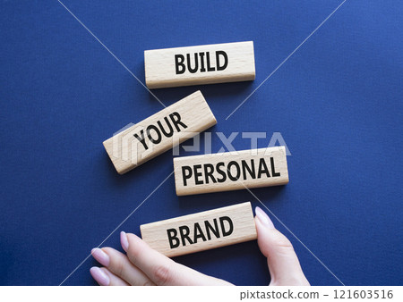 Build your personal Brand symbol. Concept words Build your personal Brand on wooden blocks. Businessman hand. Beautiful deep blue background. Business and Build your personal Brand concept. Copy space Build your personal Brand symbol. Concept words Build your personal Brand on wooden blocks. Businessman hand. Beautiful deep blue background. Business and Build your personal Brand concept. Copy space 121603516