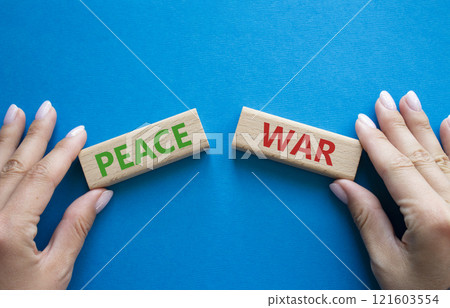 War or Peace symbol. Concept word War or Peace on wooden blocks. Businessman hand. Beautiful blue background. Business and War or Peace concept. Copy space 121603554