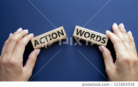 Action or words symbol. Concept word Action or words on wooden blocks. Businessman hand. Beautiful deep blue background. Business and Action or words concept. Copy space Action or words symbol. Concept word Action or words on wooden blocks. Businessman hand. Beautiful deep blue background. Business and Action or words concept. Copy space 121603556