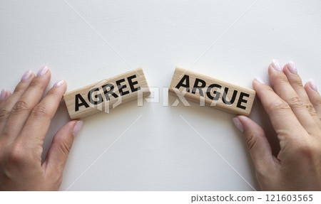 Agree or Argue symbol. Concept word Agree or Argue on wooden blocks. Businessman hand. Beautiful white background. Gender and Agree or Argue concept. Copy space 121603565