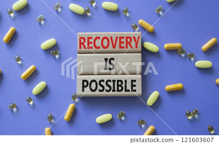 Recovery is possible symbol. Concept words Recovery is possible on wooden blocks. Beautiful purple background with pills. Healthcare and Recovery is possible concept. Copy space. 121603607
