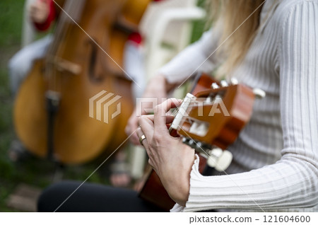 Closeup view of guitar and cello duo in action Closeup view of guitar and cello duo in action 121604600
