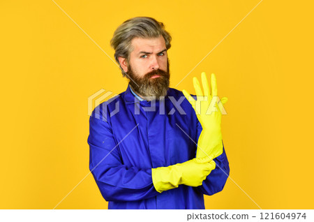 bearded man wear rubber gloves. mature janitor in uniform yellow background. spring cleaning service. protect your hands with yellow gloves. coronavirus prevention. Husband clean house bearded man wear rubber gloves. mature janitor in uniform yellow background. spring cleaning service. protect your hands with yellow gloves. coronavirus prevention. Husband clean house 121604974
