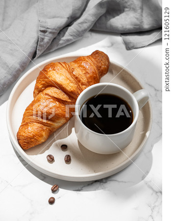Cup of espresso coffee and fresh croissant on white plate on marble background with shadow Cup of espresso coffee and fresh croissant on white plate on marble background with shadow 121605129
