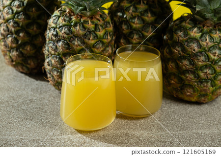 Pineapple juice in glasses among fresh pineapples. Pineapple juice in glasses among fresh pineapples. 121605169