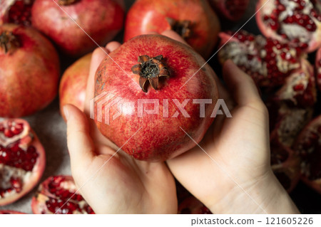 Ripe pomegranate in the hands, the concept of benefits and vitamins. Ripe pomegranate in the hands, the concept of benefits and vitamins. 121605226